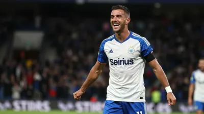 A photorealistic image of an anonymous Sirius player in a white jersey with blue sleeves and shorts, taken with a 50mm...