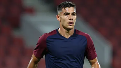 Mid-shot of a focused 24-year-old Sirius midfielder, muscular build, shoulders forward, eyes sharp, wearing a plain navy...