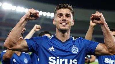 A Sirius player in a blue jersey, mid-20s, celebrating with fans after a goal
